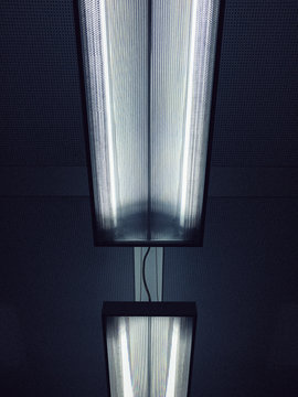 Low angle view of illuminated fluorescent lights on ceiling
