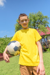 Naklejka premium Boy with ball on green lawn. Summer time!