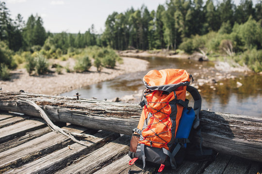 Orange backpack on wooden bridge in forest