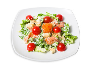 Caesar salad with salmon, croutons, Parmesan cheese and cherry tomatoes on a white plate. Isolated on white background