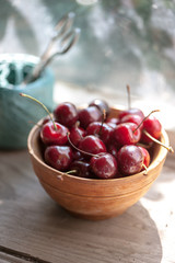Cherries in a wooden bowl on a wooden table 