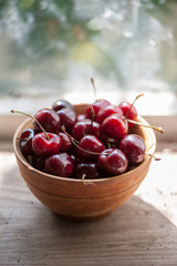 Cherries in a wooden bowl on a wooden table 