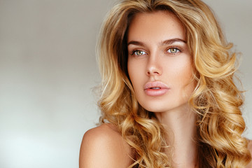 Naklejka premium beautiful, tender, sexy blonde girl with long hair and puffy lips without makeup posing in pink lingerie on a white background. soft focus, space for text