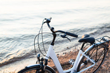 Fototapeta na wymiar White comfort bicycle at the beach in a rays of sun