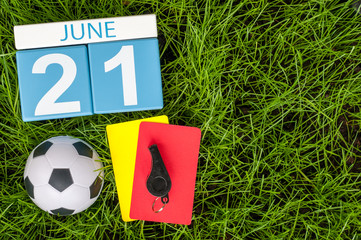 June 21st. Image of june 20 wooden color calendar on green grass background with football outfit....
