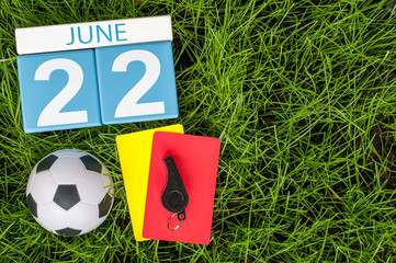 June 22nd. Image of june 22 wooden color calendar on green grass background with football outfit....