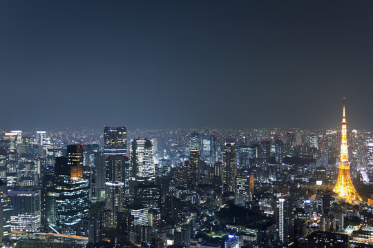 Illuminated Tokyo Tower amidst cityscape against sky at night