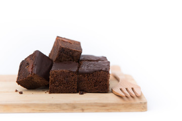 Stack of three pieces of chocolate brownie cake on a wooden.