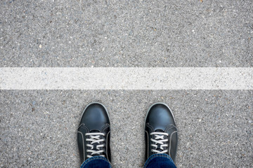 Black casual shoes standing at the white line - obrazy, fototapety, plakaty