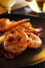 Fried shrimps with light beer glass on dark plate, close-up