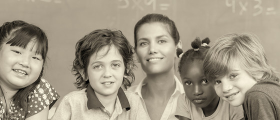 Schoolmates and teacher together smiling in classroom
