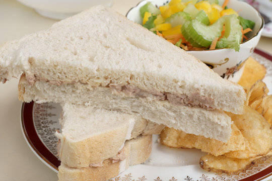 Tuna mayonnaise sandwich with a side salad and potato chips