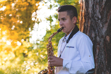 Young gypsy saxophone player.Colored and under exposed photo 