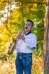 Young gypsy saxophone player.Colored and under exposed photo 