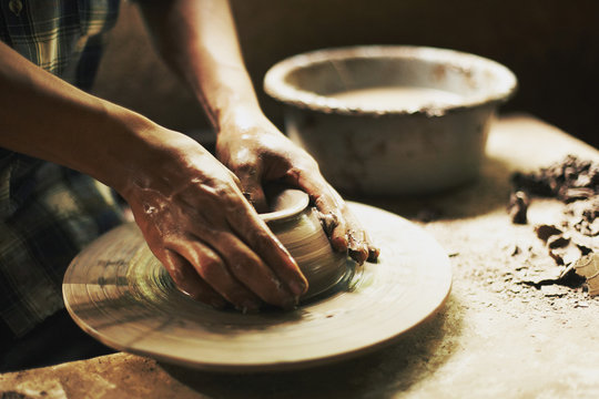 Cropped image of potter moulding clay in workshop