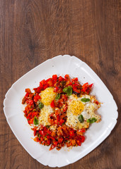 fried eggs with vegetables and cheese in a plate on wooden table