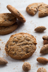 Cookies pile with chocolate chip and almond on light textile background. Delicious morning snacks for breakfast, brunch and lunch. Appetizing, healthy and fast food