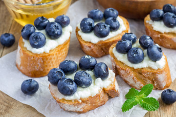 Crostini with ricotta cheese, blueberries and honey