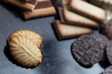 Cookies assorted on black background. Delicious morning snacks for breakfast, brunch and lunch. Appetizing, sweet and fast food.
