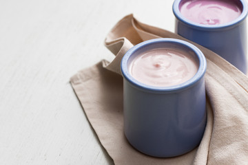 Yogurts assortment  in ceramic bowls on wooden ligth background.