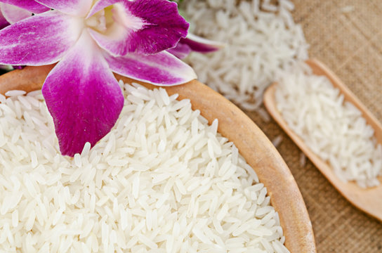 Raw white rice in wooden bowl.