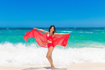 Young beautiful Asian girl in red cloth on the beach
