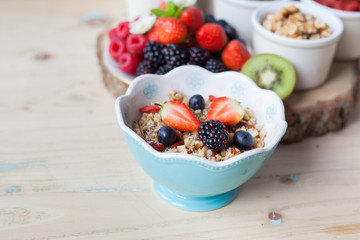 Paleo style breakfast: gluten free grain free oat free granola with mixed nuts, and fresh berries and fruits, selective focus