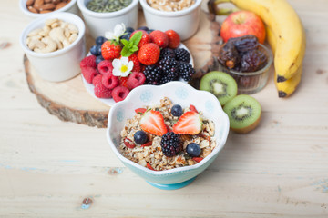 Paleo style breakfast: gluten free grain free oat free granola with mixed nuts, and fresh berries and fruits, selective focus