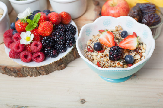 Paleo style breakfast: gluten free grain free oat free granola with mixed nuts, and fresh berries and fruits, selective focus