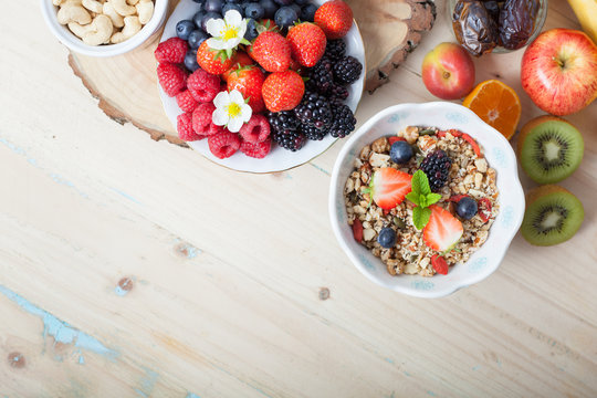 Paleo style breakfast: gluten free grain free oat free granola with mixed nuts, and fresh berries and fruits, selective focus