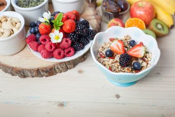 Paleo style breakfast: gluten free grain free oat free granola with mixed nuts, and fresh berries and fruits, selective focus