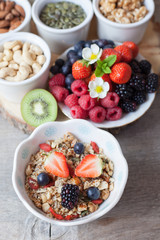 Paleo style breakfast: gluten free grain free oat free granola with mixed nuts, and fresh berries and fruits, selective focus