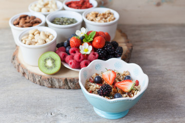 Paleo style breakfast: gluten free grain free oat free granola with mixed nuts, and fresh berries and fruits, selective focus