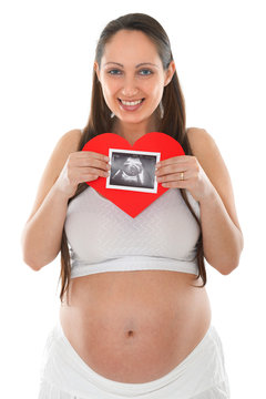 Pregnant woman holding ultrasound scan photo and paper heart. Isolated on white background.