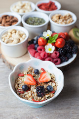 Paleo style breakfast: gluten free grain free oat free granola with mixed nuts, and fresh berries and fruits, selective focus