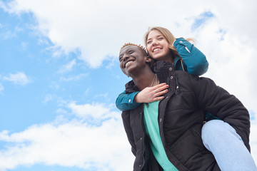 Loving Young International Couple on Sky Background. African Guy and Caucasian Woman