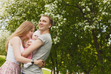 Fototapeta premium Young couple with newborn son outdoors in spring
