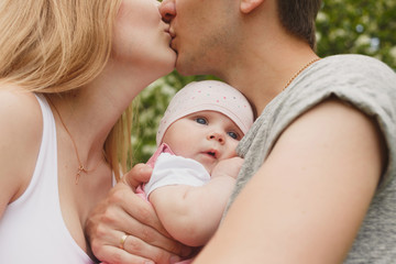 Young couple with newborn son outdoors in spring