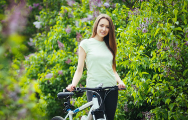 Naklejka premium Happy young girl cyclist standing with a mountain bike and. Adventure travel.