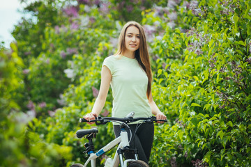 Happy young girl cyclist standing with a mountain bike and. Adventure travel.