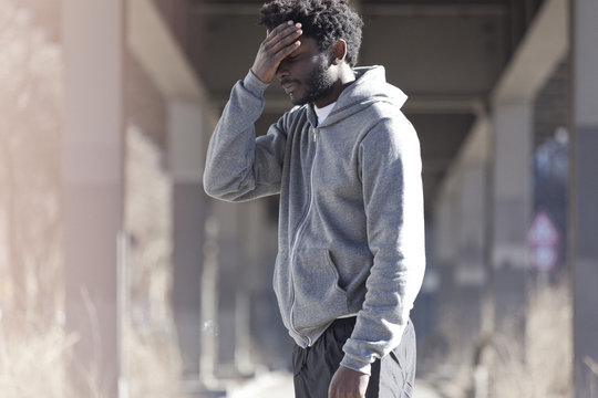A man with his hand on his forehead with a look of dejection