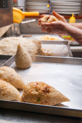 Closeup view of one just modelled sicilian arancini with its typical cone shape
