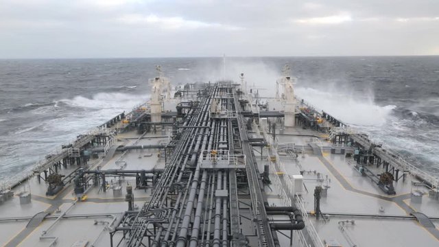 Crude oil tanker proceeding through stormy ocean