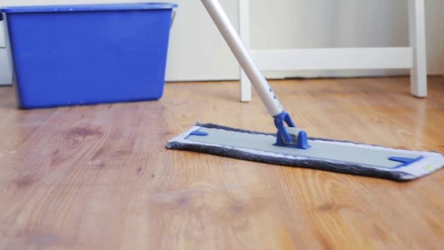 woman with mop cleaning floor at home