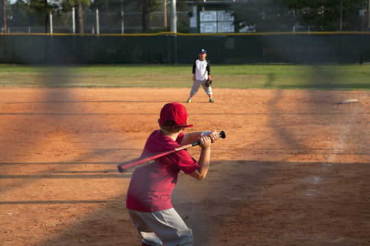 Boy preparing to swing a bat on baseball pitch