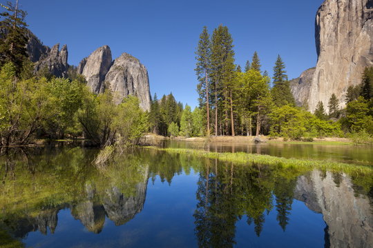 El Capitan, a 3000 feet granite monolith on the right, Cathedral Rocks and Cathedral Spires on the left, with the Merced River flowing through flooded meadows of Yosemite Valley, Yosemite National Park, Sierra Nevada, Californi