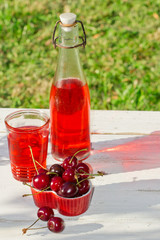 sweet cherries in a heart box on wooden table in the garden