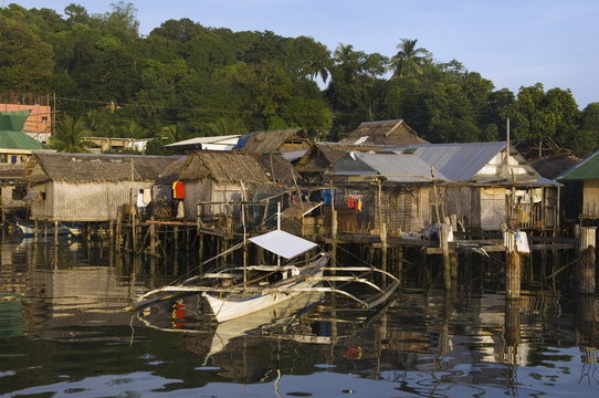 Waterfront stilt houses and catamaran fishing boat, Coron Town, Busuanga Island, Palawan Province, Philippines