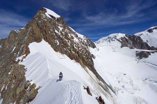 Climber on snow ridge, Aiguille de Bionnassay on the route to Mont Blanc, French Alps, France