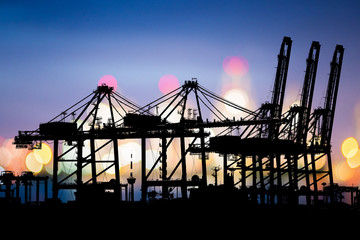 Logistic Import Export background, Bokeh of Port cranes working at night in sea port, Shipping, Logistics, Transportation Systems, Industrial Container Cargo freight ship.